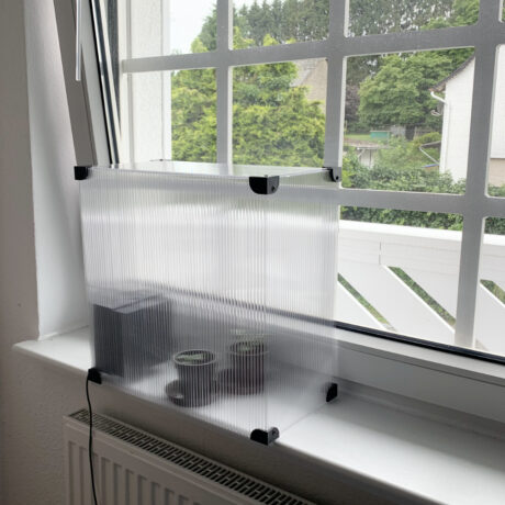 Mini Grow Box Outdoor steht indoor auf einer Fensterbank
